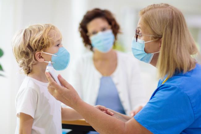 רופאה מודדת חום לילד קטן עקב חשש לקורונה 